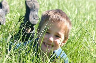 Veselé dítě v trávě si nedává pozor na klíšťáky